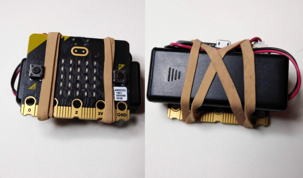 micro:bit attached to battery pack with rubber band